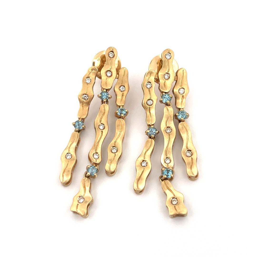 Boucles d’oreilles pendantes qui allient élégance contemporaine et savoir-faire artisanal.